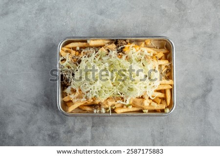 A top down view of a tray of loaded fries.