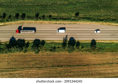 Top down view of truck, minivan and car on road from drone pov, vehicles driving down the roadway in summer afternoon