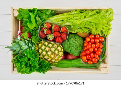 Top Down View Of Variety Vegetables And Fruits In Wooden Box In The Studio. Isolated On White Background