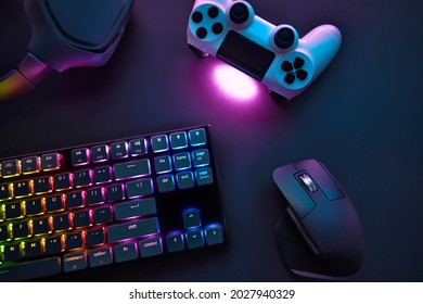 Top down view of various gaming accessories laying on table. Colorful illuminated devices. Professional computer game playing, esport business and online world concept. - Shutterstock ID 2027940329