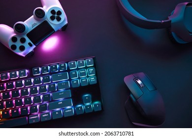 Top down view of various gaming accessories laying on table. Colorful illuminated devices. Professional computer game playing, esport business and online world concept. - Shutterstock ID 2063710781