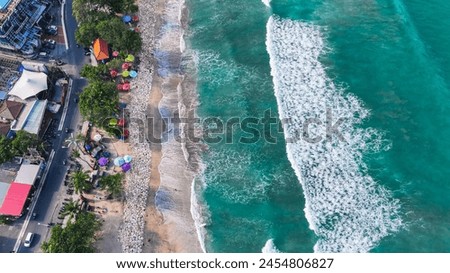 Top down view of various hotels and resorts that line the sandy Kuta beach in Bali, Indonesia in Southeast Asia.