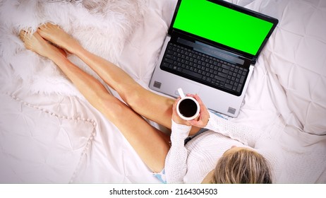 Top Down View Of A Woman Sitting On The Bed Using Laptop Computer Drinking Coffee