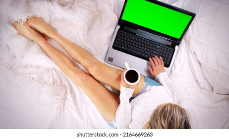 Top Down View Of A Woman Sitting On The Bed Using Laptop Computer Drinking Coffee