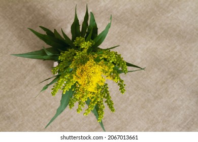Top Down View Of Yellow Goldenrod Bouquet; Goldenrod Bouquet On A Beige Table Cloth