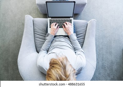 Top Down View Of Young Blond Person Typing On Laptop Computer