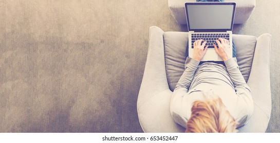 Top Down View Of Young Blond Person Typing On Laptop Computer