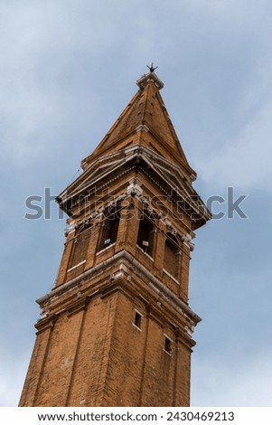 Top of famous leaning bell tower Campanile Pendente of Saint Martin Bishop Church on Burano island, Venice, Italy.