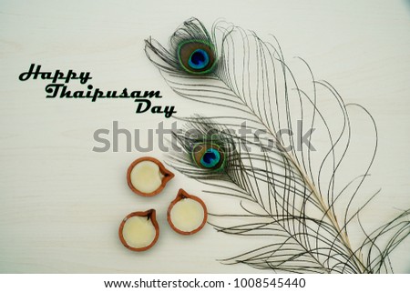 Top or flat lay view of a peacock feathers on a wooden background with a words HAPPY THAIPUSAM DAY. Celebrate by a hindu religions.  A religions conceptual.