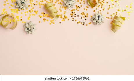 Top Frame Border Of Golden Confetti And Party Decoration On Beige Background. Christmas Party Or Happy Birthday Card Mockup.