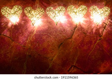 At the top of the frame are five handmade braided decorative hearts, illuminated by lights against a red marble backdrop. At the bottom there is a place for inscriptions for different holidays