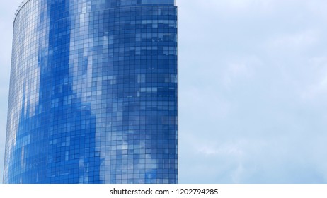 Top Of The Glass Business Center Against The Blue Sky. High Building. Many Square Windows.