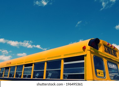 The Top Half Of Any Empty School Bus Under A Blue Sky.