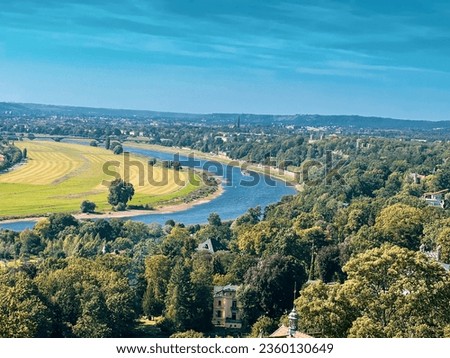 Top hill panoramic view of Elbe Labe River waterway from monorail operated by DVB green nature and long river Elbe with iconic passenger on the frame luckily clear blue sun shining sky