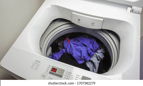 Top Load Washing Machine With Clothes Loaded.