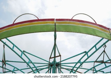 The Top Of The Merry Go Round With A White Sky Background During The Day