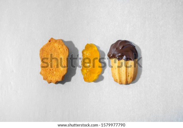 Top minimal view of a petit\
four cookie in pieces, bottom biscuit, marmalade in the center and\
top biscuit with chocolate garnishment. Pastry shop banner\
concept.