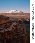 The top of Mount Elbrus. The Caucasus Mountains. View of Elbus from the Bermamyt plateau. A rock and a snow-covered sleeping volcano.