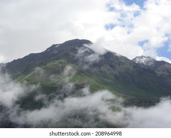 the top of the mountain in the clouds