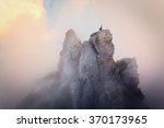 Top of the mountains. High rocks in fog at sunset. Colorful nature background