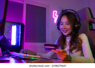 Top Up Online Game With Credit Card Concept. Gamer And E-Sport Online Of Asian Woman Playing Online Computer Video Game With Lighting Effect, Broadcast Streaming Live At Home. Gamer And E-Sport Gaming