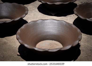 The top part of the clay jar, drying under the sunlight, reveals its smooth texture and even edges, basking in warmth as it prepares for the next stage of finishing. - Powered by Shutterstock