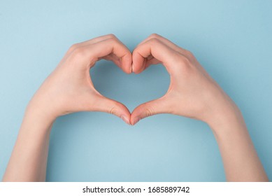 Top pov above overhead close up view photo of hands making shape of heart isolated over blue pastel color background