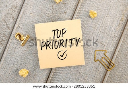 Top Priority Note on Sticky Paper with Office Workspace Concept