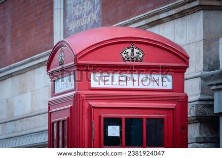 The top of a red British telephone booth on the street