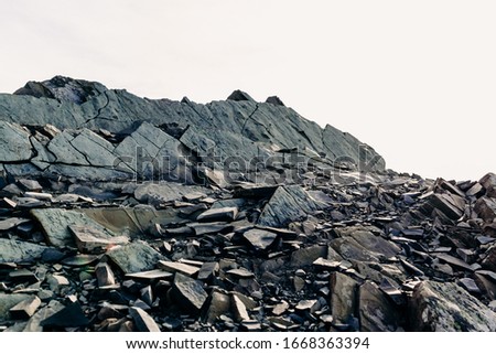 The top of a rocky mountain range. Gray flat stones. Rocky rock
