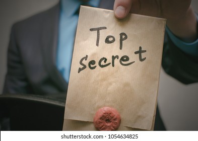 Top Secret Concept. Open The Secret. Business Man Takes Out Secret Documents From His Hat. Confidential Dossier Information. Super Important Information.