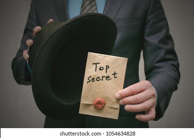 Top Secret Concept. Open The Secret. Business Man Takes Out Secret Documents From His Hat. Confidential Dossier Information. Super Important Information.