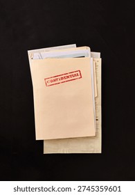 Top secret file folder with documents inside on dark background. Concept of confidential information, data leak, corporate secrets, investigation and security breach.