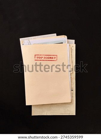 Top secret file folder with documents inside on dark background. Concept of confidential information, data leak, corporate secrets, investigation and security breach.