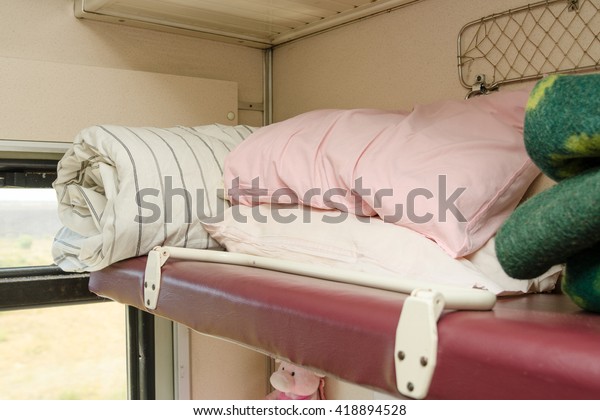 The top shelf in the second-class compartment of\
the train wagon with\
bedding