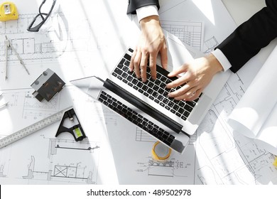 Top Shot Of Architect Workplace: Notebook Computer, Ruler, Taping Measure, Compass And Scale Model House. Interior Designer Working On New Project In 3D CAD Application, Using Laptop, Keyboarding