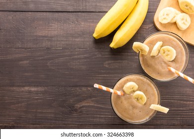 Top shot banana smoothie on wooden background.