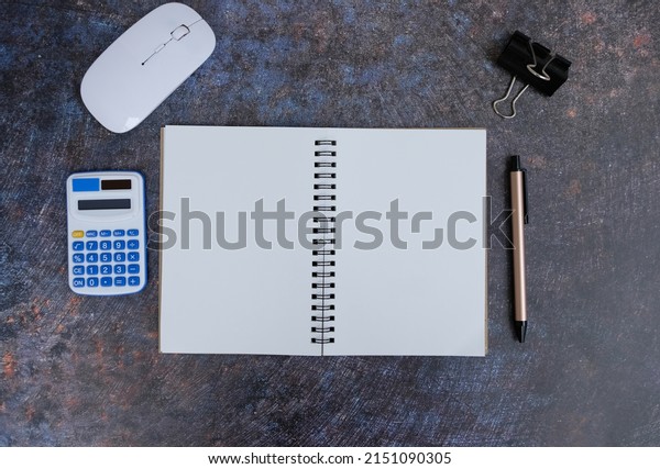Top shot of an office table desk in a flat lay.\
Blank laptop, office materials, pencil, and office supplies. Top\
view with copy space, flat\
lay.