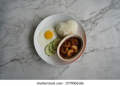 Top Shot Of Sambal Prawn Served With White Rice, Fried Egg And Slice Cucumber