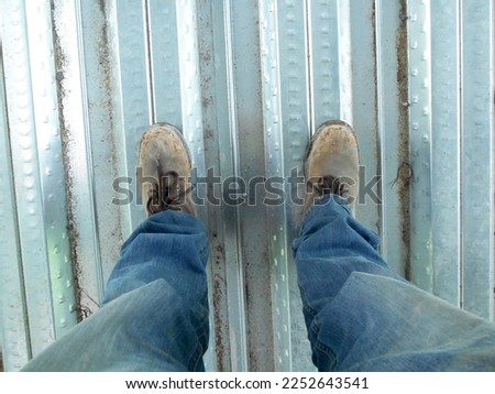 Top or side view of construction worker standing on construction site while wearing safety shoes. The shoes are dirty and dusty. Foto stock © 