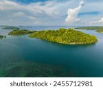 Top survey of cluster of islest under blue sky and clouds. Blue sea and corals. Once Islas. Mindanao, Philippines.