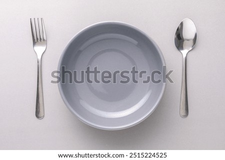 Top Table View of Empty gray bowl with fork and spoon on gray background
