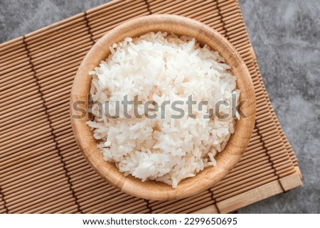 Top Table View Of Thai Jasmine Rice in Wooden Bowl,  staple food of Thailand and Asia, providing energy in every meal.