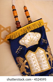 The Top Of A Torah, The Scrolled First Five Books Of The Hebrew Bible, In A Velvet Cover On A Cloth With A Star Of David Motif.