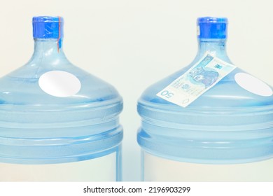 The Top Of Two Plastic Gallon Water Bottle Containers With White Round Labels And 50 Zlotych Stand On A White Background. Refreshment. Retail. Water. Refresh. Cooling. Stand. Cold. Delivering