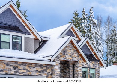 The Top Of A Typical American Home In Winter. Snow Covered Roof And Nice Window.