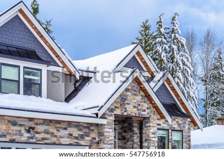 The top of a typical american home in winter. Snow covered roof and nice window.