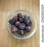 top veiw ajwa dates with glass bowl isolated on wooden background 