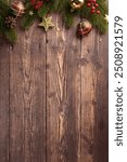 Top vertical view of Christmas decorations on a rustic wooden background, featuring festive ornaments, greenery, and a cozy holiday atmosphere