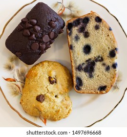 Top View Of 3 Vegan Cookies. Chocolate Cookie, Chocolate Chip Cookie And A Banana Bred With Blueberries. White Background. 